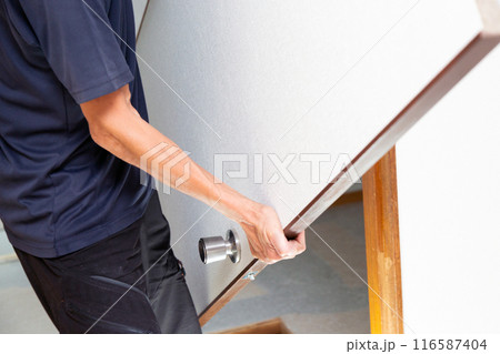 中古住宅のドアを取り付ける手元 116587404