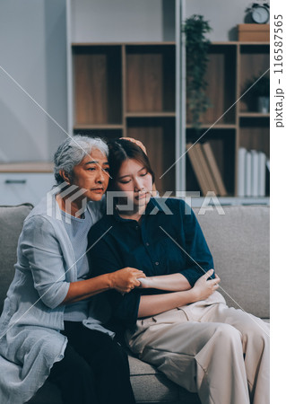 Sad teen granddaughter hugging depressed mature grandmother, giving support, help, comforting, consoling granny. Teenage daughter girl and middle aged mother going through family problems Sad teen granddaughter hugging depressed mature grandmother, giving support, help, comforting, consoling granny. Teenage daughter girl and middle aged mother going through family problems 116587565