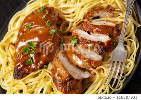 Chicken Lazone with sauce and linguine on plate Chicken Lazone with sauce and linguine on plate 116587933
