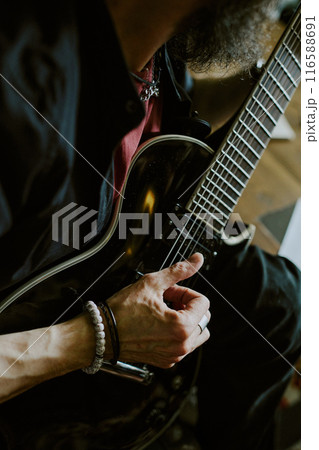 Vertical high angle view medium closeup of unrecognizable rock musician practicing guitar playing 116588691