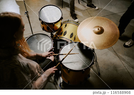 High angle view of unrecognizable female rock musician practicing playing drums, copy space 116588908