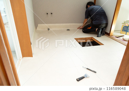 中古住宅のリフォームで水回りの床にフロアタイルを貼るクロス職人 116589048