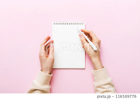 Woman hand with pencil writing on notebook. Woman working on office table. Female hand holding pencil and sketchbook. Mock-up Concept Woman hand with pencil writing on notebook. Woman working on office table. Female hand holding pencil and sketchbook. Mock-up Concept 116589776
