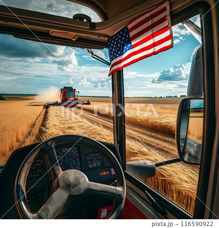 the combine harvester harvests wheat in the field with flag USA the combine harvester harvests wheat in the field with flag USA 116590922