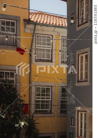 There is a yellow building painted with a red flag waving from its balcony There is a yellow building painted with a red flag waving from its balcony 116591865