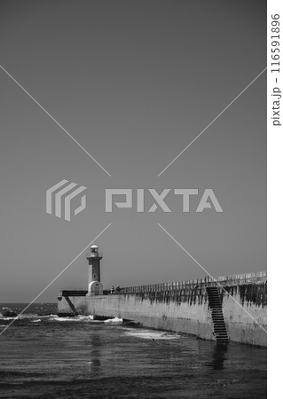 A black and white photo of a lighthouse in the ocean A black and white photo of a lighthouse in the ocean 116591896