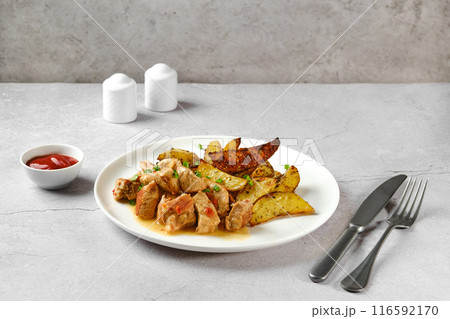 Beef goulash with baked potato wedges 116592170