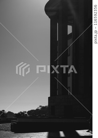 In front of a building, there is a black and white photo of a statue 116592356