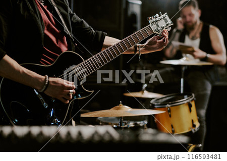 Unrecognizable rock musician playing in band preparing for performance tuning electric guitar, copy space Unrecognizable rock musician playing in band preparing for performance tuning electric guitar, copy space 116593481