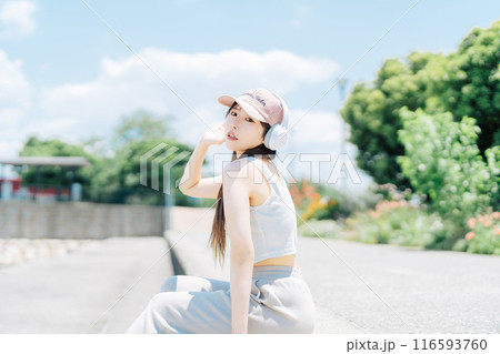 屋外で音楽を聴く若い女の子 116593760