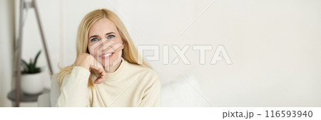 Portrait Of Mature Beautiful Blonde Woman Smiling At Camera, Resting At Home, Panorama with Copy Space Portrait Of Mature Beautiful Blonde Woman Smiling At Camera, Resting At Home, Panorama with Copy Space 116593940