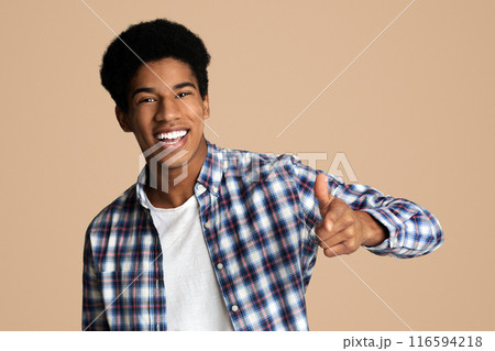 Hey you. Cheerful black guy indicating happily at camera, white studio background 116594218