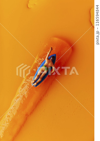 miniature surfer man on an orange freeze pop miniature surfer man on an orange freeze pop 116594844