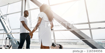African American couple walks hand-in-hand through an airport terminal, luggage in tow. They appear to be heading towards their gate, excited for their journey, copy space African American couple walks hand-in-hand through an airport terminal, luggage in tow. They appear to be heading towards their gate, excited for their journey, copy space 116594956
