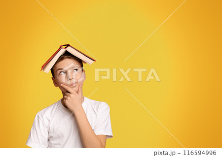 Pensive boy with book on head thinking on orange background, panorama with copy space 116594996