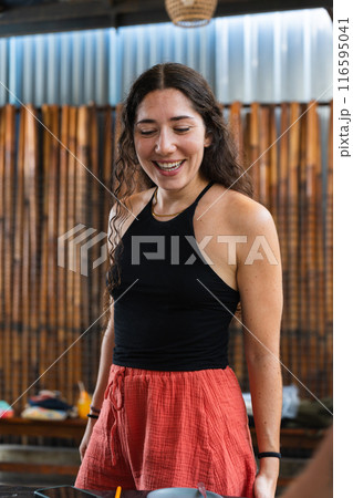 Young teacher looking at her children's work happily during back to school. Vertical 116595041