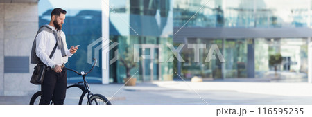 Man checking his mobile phone standing on street with his bicycle while commuting to office, copy space, web-banner Man checking his mobile phone standing on street with his bicycle while commuting to office, copy space, web-banner 116595235