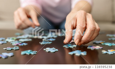 Memory training. Senior woman playing puzzle at home, closeup 116595238