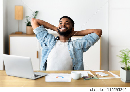 Smiling millennial businessman having rest at contemporary working place, leaning back in chair Smiling millennial businessman having rest at contemporary working place, leaning back in chair 116595242