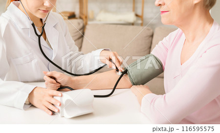 Doctor measuring arterial blood pressure for senior woman patient. Health care in hospital, empty space Doctor measuring arterial blood pressure for senior woman patient. Health care in hospital, empty space 116595575