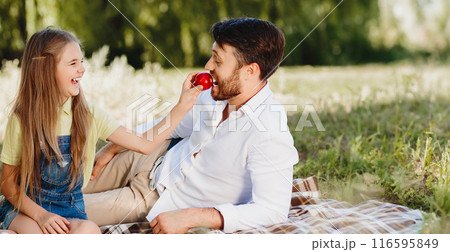 Happy family relaxing in park, eating fruits at picnic and having fun 116595849