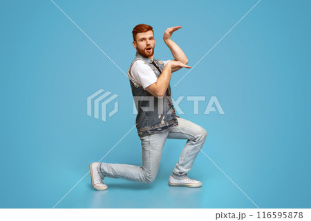 Funny millennial guy dancing in egypt style on blue background, studio, copy space 116595878