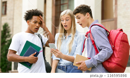 Failed tests. Shocked classmates checking exam results on smartphone, resting in college campus Failed tests. Shocked classmates checking exam results on smartphone, resting in college campus 116595898