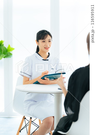 患者に問診する医療従事者の女性 116595911