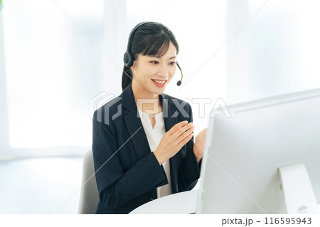 電話応対する女性オペレーター　コールセンター　カスタマーサポート 116595943