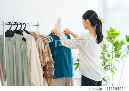 アパレルショップで商品を陳列する女性店員 116595954