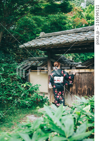 春風萬里荘の門の前にいる女性の後ろ姿 春風萬里荘の門の前にいる女性の後ろ姿 116596521