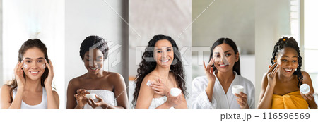Five multiethnic women are smiling as they apply moisturizer to their faces and bodies in their bathrooms. They dressed in bathrobes or towels, and each woman is holding a container of moisturizer 116596569
