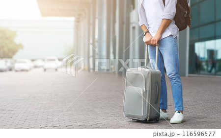 Waiting For Transfer. Unrecognizable Man Standing Near Airport Terminal With Luggage, Cropped Image, Panorama With Empty Space 116596577