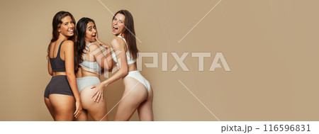 Laughing millennial different women in underwear with open mouth have fun, enjoy beauty care, isolated on beige background. Self love, wellness and anti cellulite treatment, surgery, copy space Laughing millennial different women in underwear with open mouth have fun, enjoy beauty care, isolated on beige background. Self love, wellness and anti cellulite treatment, surgery, copy space 116596831