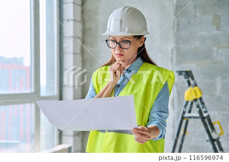Technical profession woman in protective vest helmet working on construction Technical profession woman in protective vest helmet working on construction 116596974