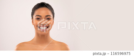 Cheerful millennial african american lady with nude makeup looking at camera, isolated on studio background, studio, close up. Beauty and skin care at home, cosmetology, fashion, copy space Cheerful millennial african american lady with nude makeup looking at camera, isolated on studio background, studio, close up. Beauty and skin care at home, cosmetology, fashion, copy space 116596975
