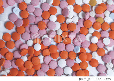 Close up of colorful round pills scattered on white background. 116597369