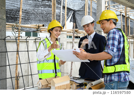Male project manager and engineers discussing project details at building site 116597580