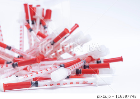 Pile of disposable Medical syringes on a white background. 116597748