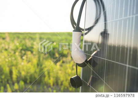 Close up of electric car charging plug with solar panel 116597978