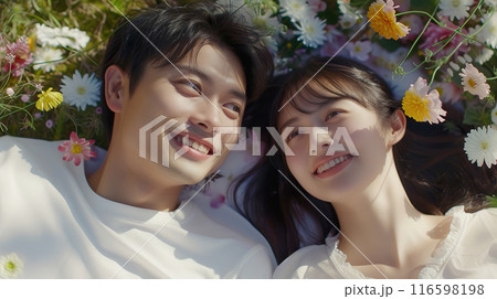 花畑に寝転ぶ幸せそうな若い男女のカップル 116598198