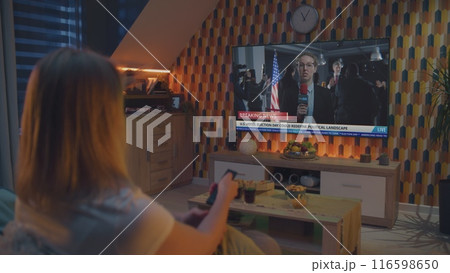 Adult couple talks and watches news broadcast report about US Election Day on TV at home Adult couple talks and watches news broadcast report about US Election Day on TV at home 116598650