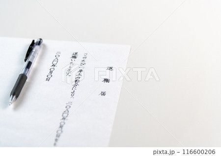 白いテーブルに置かれた手書きの退職届とゲルインクの黒ペン 116600206