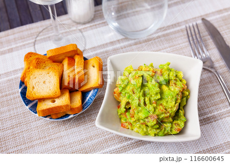 Guacamole and toasted bread served on white plate 116600645