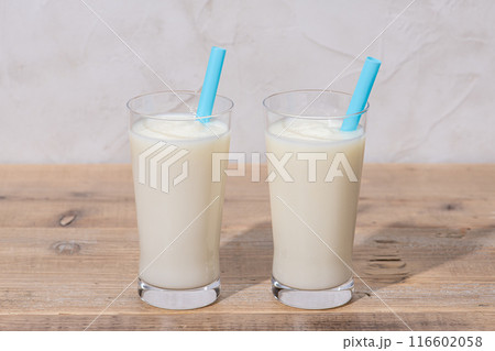 テーブルの上にストローを刺したバニラシェーク 116602058