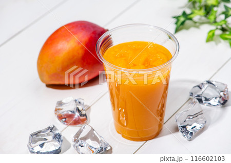 白板のテーブルにプラスチックのコップにはいったマンゴースムージー 白板のテーブルにプラスチックのコップにはいったマンゴースムージー 116602103