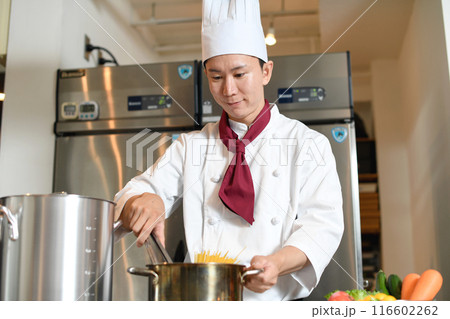 厨房でパスタを茹でるアジア人の男性調理師 厨房でパスタを茹でるアジア人の男性調理師 116602262