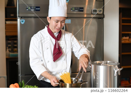 厨房でパスタを茹でるアジア人の男性調理師 厨房でパスタを茹でるアジア人の男性調理師 116602264