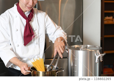 厨房でパスタを茹でるアジア人の男性調理師 厨房でパスタを茹でるアジア人の男性調理師 116602265