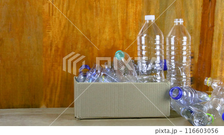 Waste plastic bottles on wooden background waiting for recycling concept of saving our environment sustainable natural resources. 116603056
